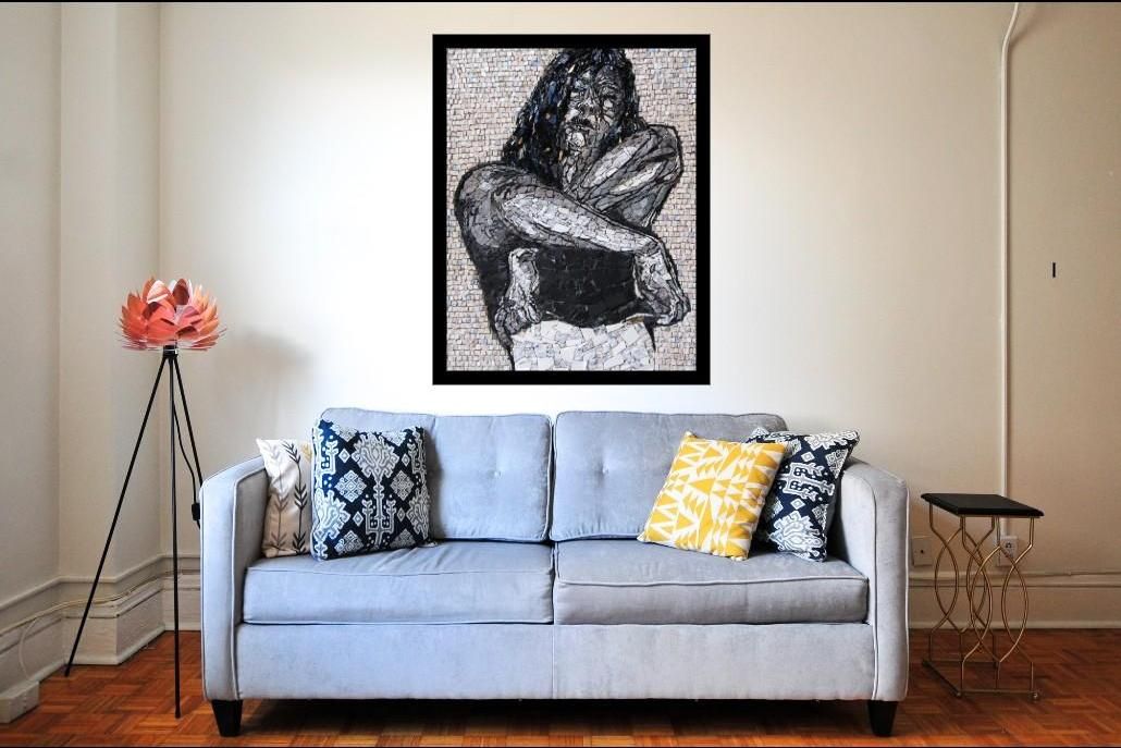A large framed mosaic portrait hung above a sofa in a living room, shown to scale