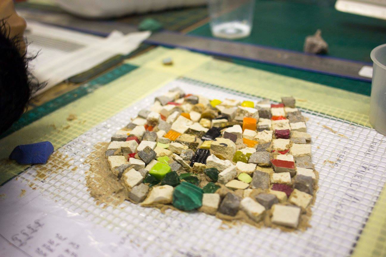 A small finished square mosaic piece in bright mixed colours