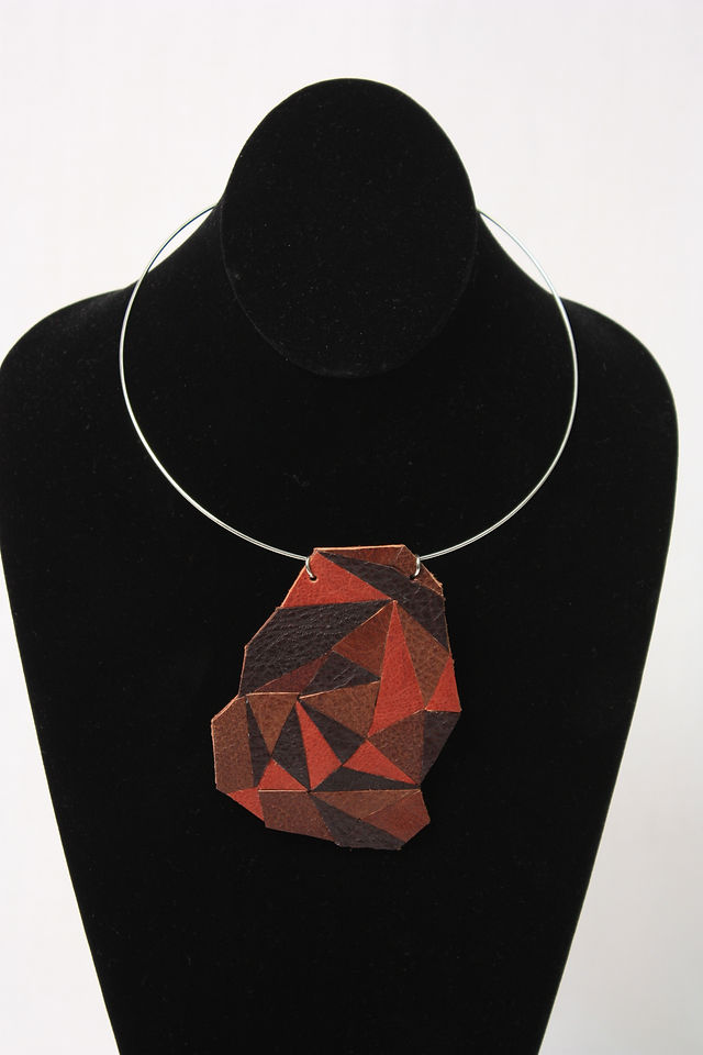 A single faceted leather pendant necklace in red, burgundy and black tones